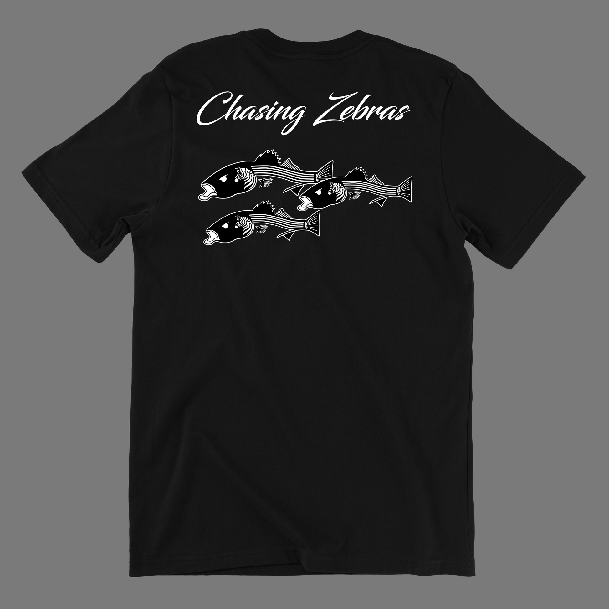 Back of a black t shirt. It says Chasing Zebras across the back and under it has a design of 3 striped bass in black and white and the striped bass have zebras on the side of their head