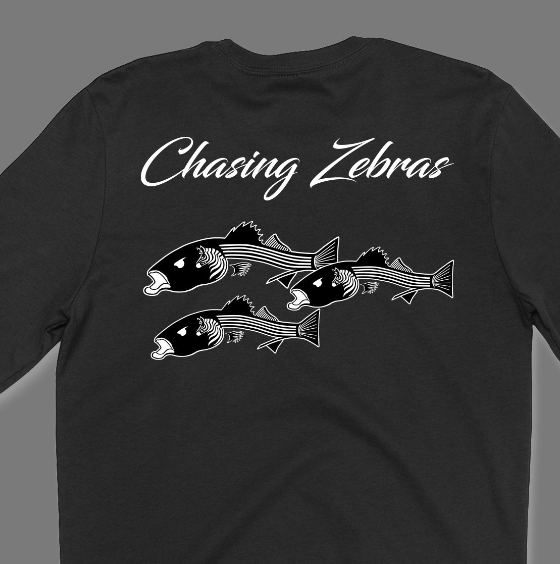 Back of a black long sleeve shirt. It says Chasing Zebras across the back and under it has a design of 3 striped bass in black and white and the striped bass have zebras on the side of their head